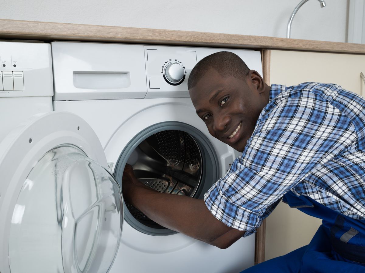 Un technicien intervient sur un lave-linge au domicile du client